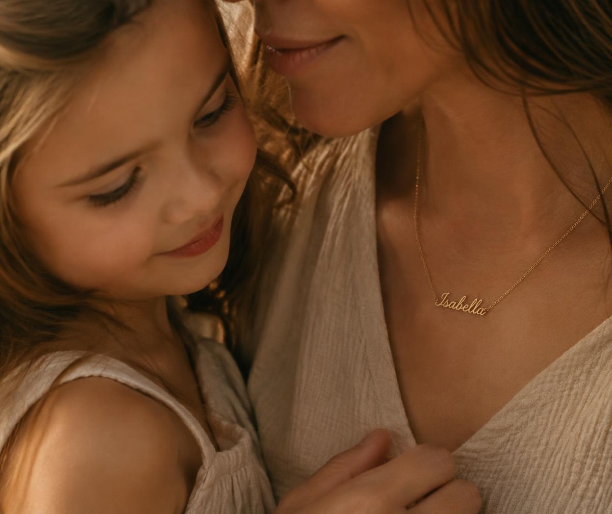 Mãe e filha com colar de nome